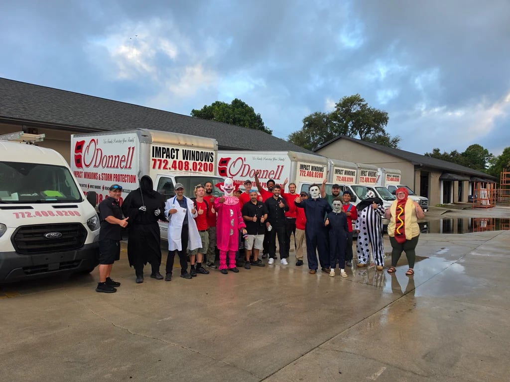 The O'Donnell team in Halloween costumes lined up in front of the company trucks.